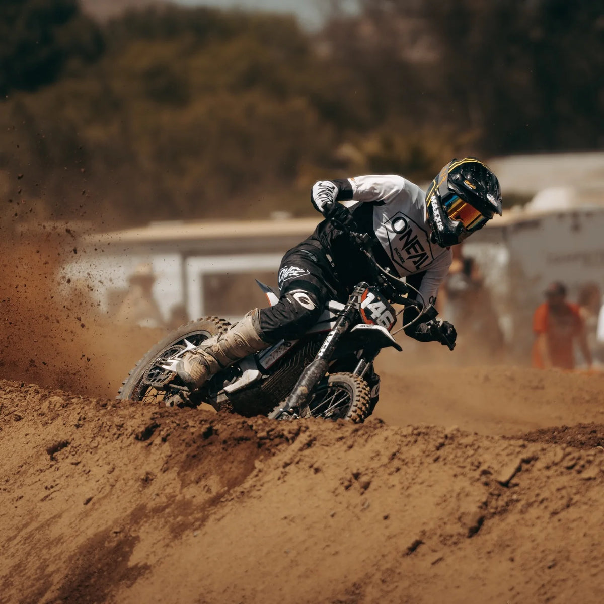 Arctic Leopard rider railing a berm, dirt flying, at the track