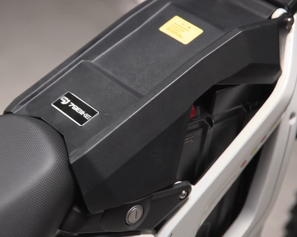 Close-up of a motorcycle seat with a visible brand logo on a gray background