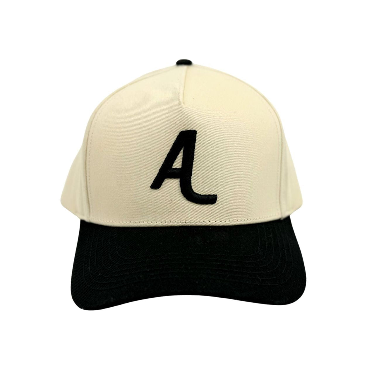 The Amped A Hat by Amped Bikes is a premium beige snapback baseball cap with a black bill and a bold black letter A embroidered on the front, shown on a plain white background.