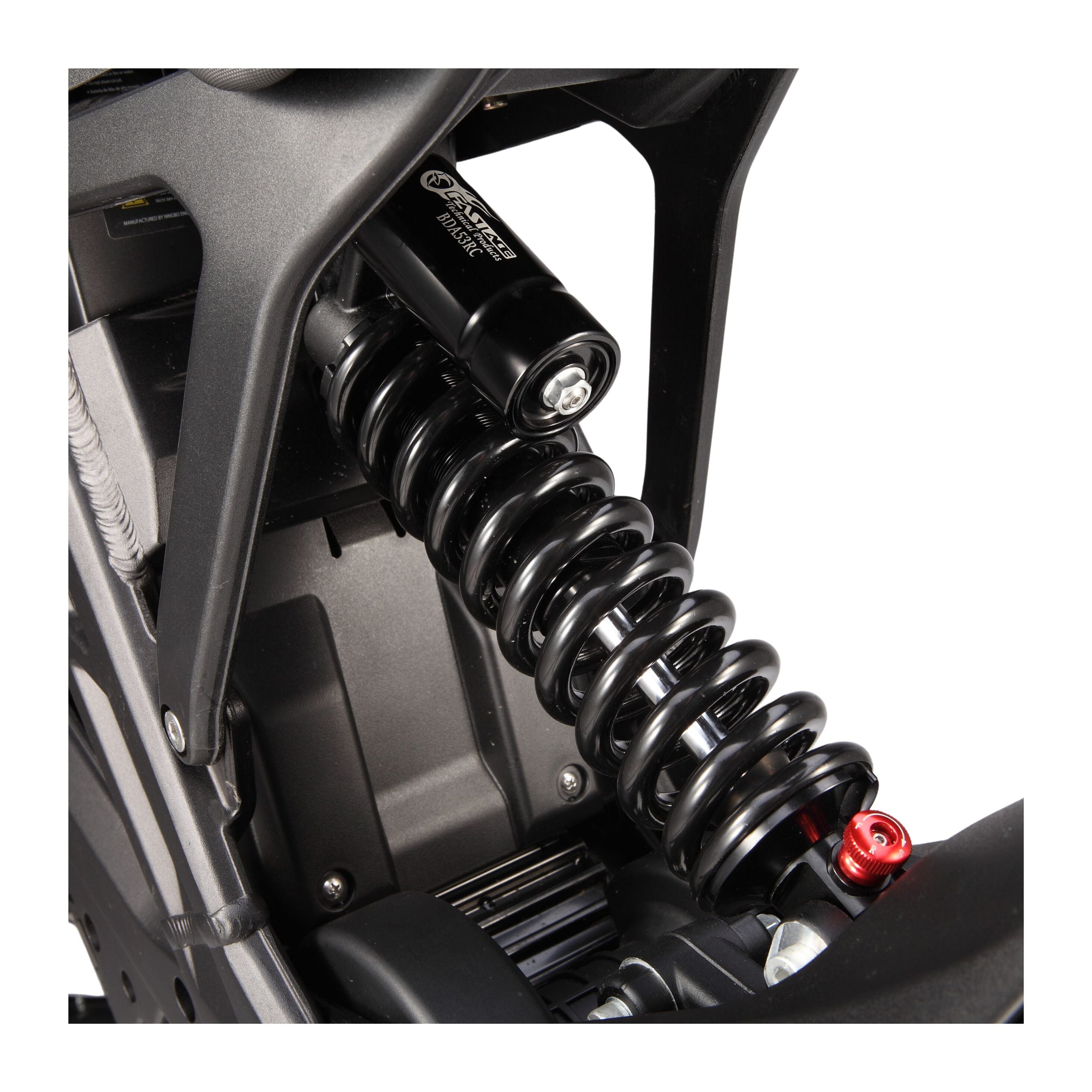Close-up of the E Ride Pro SS 3.0’s suspension system with a black coil spring and shock absorber. The electric dirt bike setup is secured by bolts, features a red adjustment knob at the bottom, and includes an advanced BMS for optimized performance.