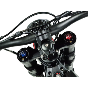 A mountain bikes handlebar and suspension fork resemble the Talaria Sting MX5 Pros precision. The image shows a top crown with blue and red adjustment knobs for tuning, with handlebar cables suggesting advanced tech akin to its 72V/40Ah battery system.