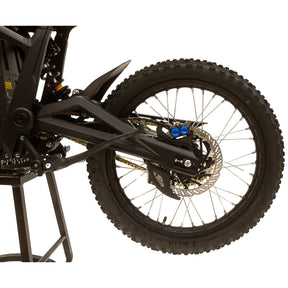 side view shot of the rear wheel and elevated on white backdrop. On the let side the frame of the bike is balancing on stand with rear shock in view